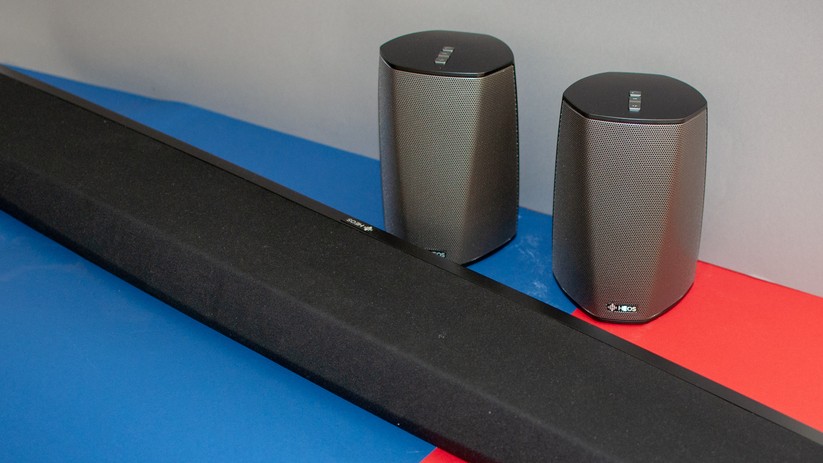 Zwei Denon-Produkte, die Heos Bar (vorne) und die Heos 1 (hinten).
