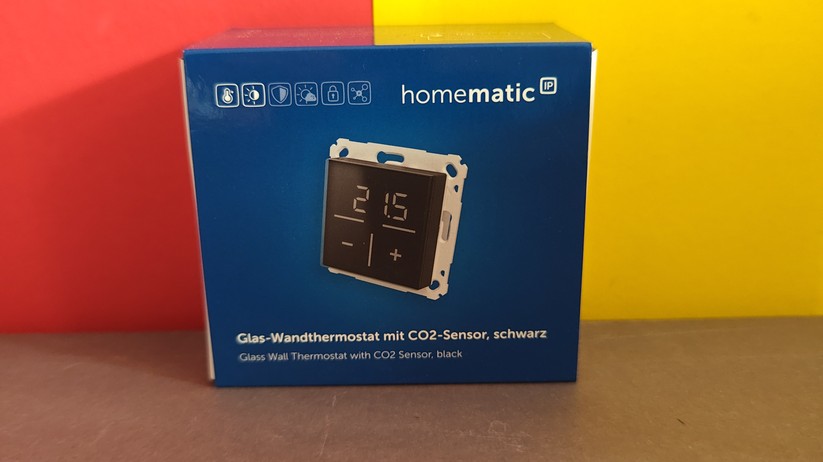Das Homematic IP Glas-Wandthermostat mit CO₂-Sensor gibt es in Schwarz oder Weiß. Auf seinem Glas-Display kann es Temperatur, Luftfeuchte und CO₂-Konzentration abwechselnd anzeigen.