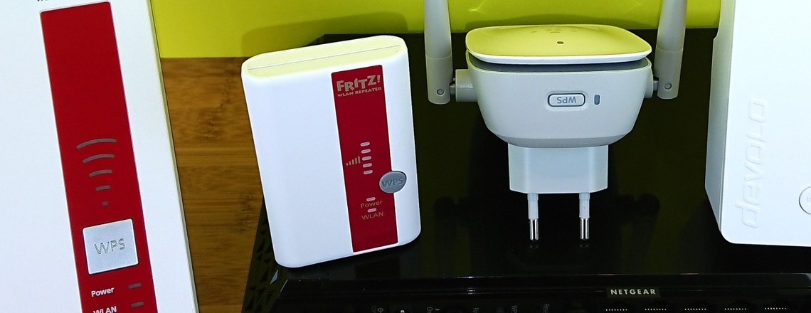 Die drei weißen WLAN-Repeater (2x AVM, 1x Devolo) haben ihren WPS-Taster direkt an der Front. Der weiß-graue Belkin N300 hat ihn unten. Der große, schwarze Netgear EX7000 hat den WPS-Knopf an seiner Hinterseite. 