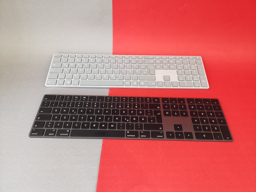 Tastaturen sind enorm hilfreich, gerade wenn die Notebook-Tastatur nicht prickelnd ist. Im Bild sind zwei High-End-Modelle zu sehen, das Microsoft Surface Keyboard (hinten) und Apple Magic Keyboard (vorne). Wer weniger ausgeben möchte, der findet ab etwa zehn Euro vernünftige Tastaturen. 