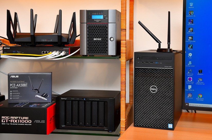 Praxis-Test-Aufbau: Wir greifen mit dem 11ax-Dell-PC (Rechts) und dessen zwei Wifi-6-Antennen über die 8 Antennen des Wifi-6-Asus-AX11000 (links oben) auf die zwei 10-Gig-NAS-Speicher (Mitte) von Buffalo und Synology zu (Bild: Harald Karcher).