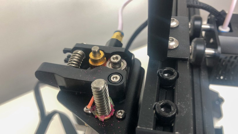 Der Extruder-Motor ist am Rahmen befestigt und führt das Filament über den weißen Schlauch zum Druckkopf (Hotend).