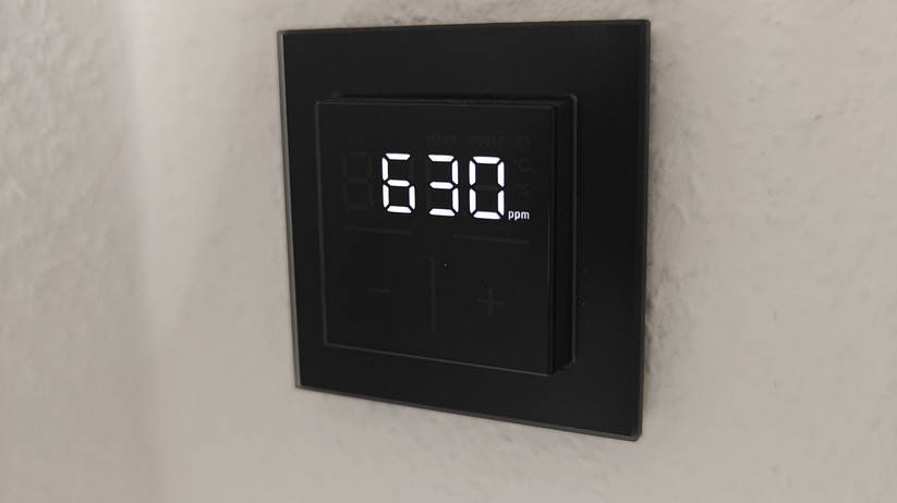 Das Homematic IP Glas-Wandthermostat mit CO₂-Sensor gibt es in Schwarz oder Weiß. Auf seinem Glas-Display kann es Temperatur, Luftfeuchte und CO₂-Konzentration abwechselnd anzeigen.