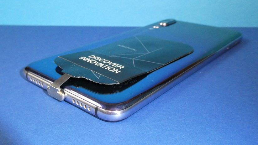 Der Qi-Empfänger wird angesteckt und auf der Rückseite fixiert.