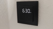 Das Homematic IP Glas-Wandthermostat mit CO₂-Sensor gibt es in Schwarz oder Weiß. Auf seinem Glas-Display kann es Temperatur, Luftfeuchte und CO₂-Konzentration abwechselnd anzeigen.