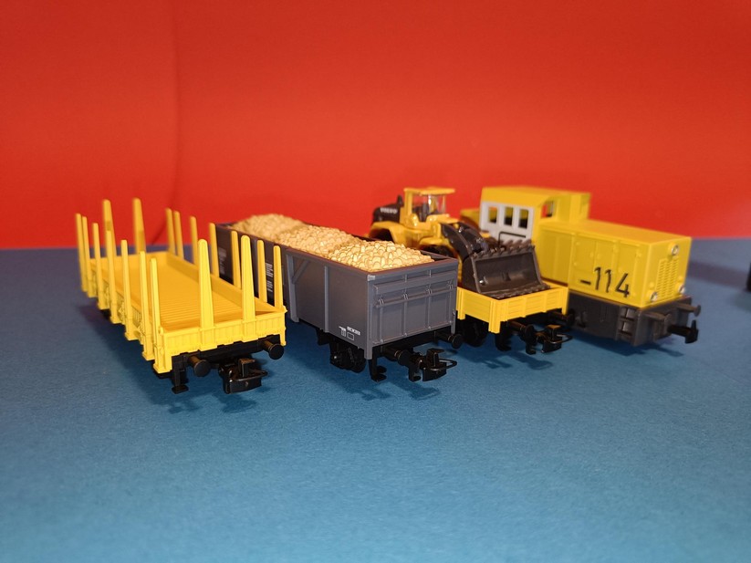Im Paket befindet sich neben Technik und Gleise ein Zug mit einer Lokomotive und mehreren Wagen.