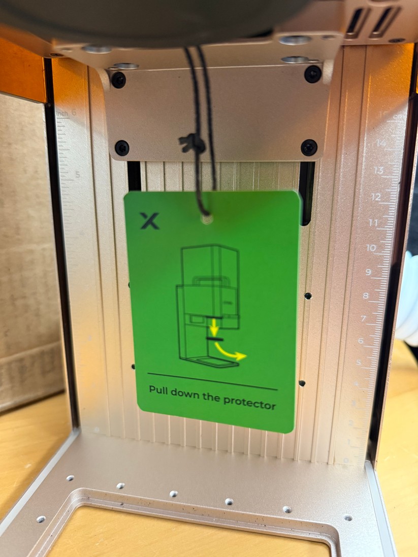 Dann gilt es, die Schutzabdeckung der Laser-Linse oben mittig abzuziehen.