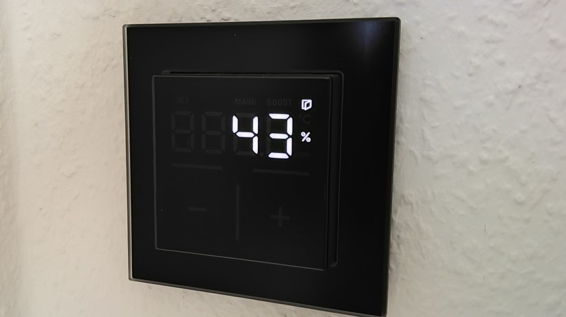 Das Homematic IP Glas-Wandthermostat mit CO₂-Sensor gibt es in Schwarz oder Weiß. Auf seinem Glas-Display kann es Temperatur, Luftfeuchte und CO₂-Konzentration abwechselnd anzeigen.