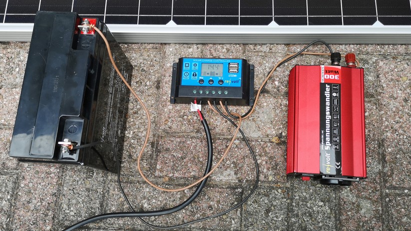 Eine Insellösung: Oben ist das Solarpaneel zu erkennen. Darunter befinden sich (v.l.n.r) der Blei-Akku, der Laderegler und der Spannungswandler.