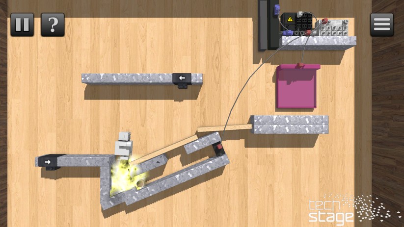 Der kleine, graue Roboter muss ins violette Ziel. In diesem Fall hat er dazu gerade eine Bombe gezündet, die eine Kugel gegen einen Schalter geschossen hat. Und dieser wiederum hat gerade noch ein Tor vor dem Ziel geöffnet.