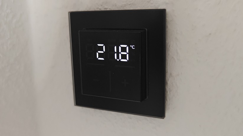 Das Homematic IP Glas-Wandthermostat mit CO₂-Sensor gibt es in Schwarz oder Weiß. Auf seinem Glas-Display kann es Temperatur, Luftfeuchte und CO₂-Konzentration abwechselnd anzeigen.