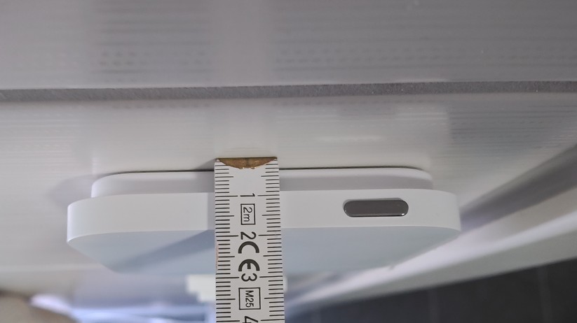 Im direkten Vergleich zur ersten Generation fällt das neue Thermostat deutlich schlanker aus. Die Halterung misst 9,3 × 9,3 cm bei nur 0,8 cm Tiefe, während die aufgesetzte Display-Einheit 10,9 × 10,9 cm groß ist und 1 cm tief aufbaut. Die Diagonale beträgt 13,6 cm – ein deutlicher Zuwachs gegenüber den 9,7 × 9,7 cm der ersten Generation. Da die Halterung kleiner ist als das Display, entsteht der Eindruck, das Thermostat würde vor der Wand schweben.