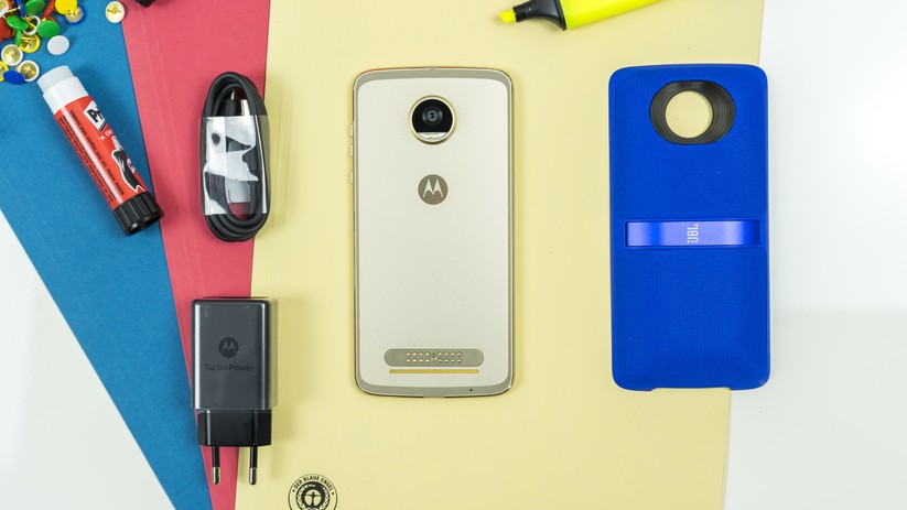 Das ist der Lieferumfang des Motorola Moto Z2 Play: Telefon, Ladekabel, Netzgerät sowie ein JBL SoundBoost 2 (beim Kunden in der Farbe Schwarz).