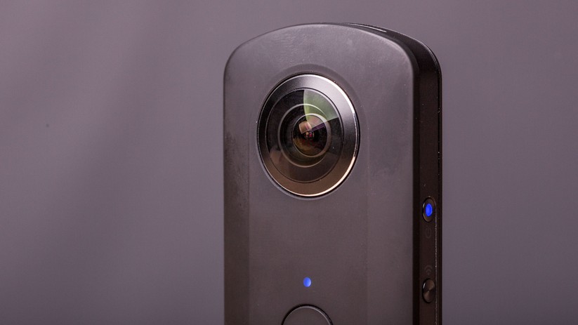 Hier ist eine der beiden stark vorgewölbten Linsen zu sehen. Darunter befindet sich der Aufnahme-Button.