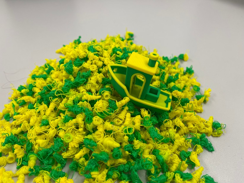 Bei jedem Farbwechsel muss der Drucker mit Materialwechsler die Düse spülen. Besonders gemein ist das Benchy mit seinen schiefen Ebenen: Hirt geht deutlich mehr Filament fürs Spülen als für das zu druckende Objekt drauf. 