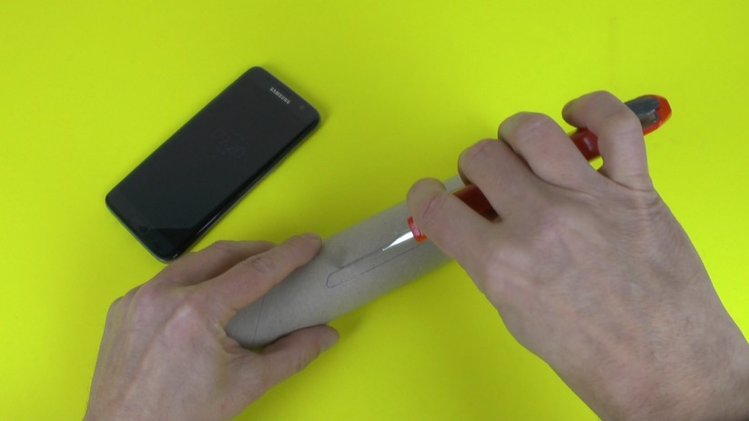 Der erste Schritt ist eine Aussparung für das Smartphone in die Papprolle zu schneiden.
