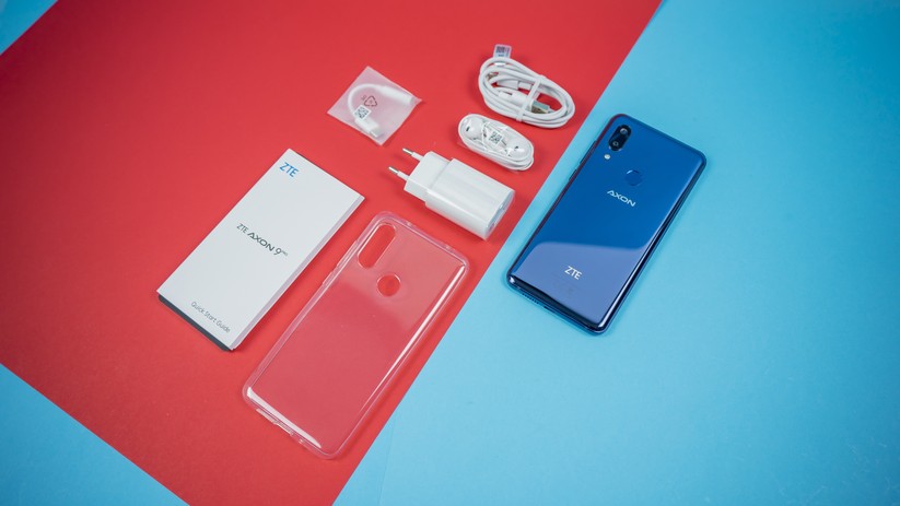 Lieferumfang des ZTE Axon 9 Pro: Ladekabel, Netzgerät, Smartphone, Kopfhörer, Adapter und Schutzhülle.