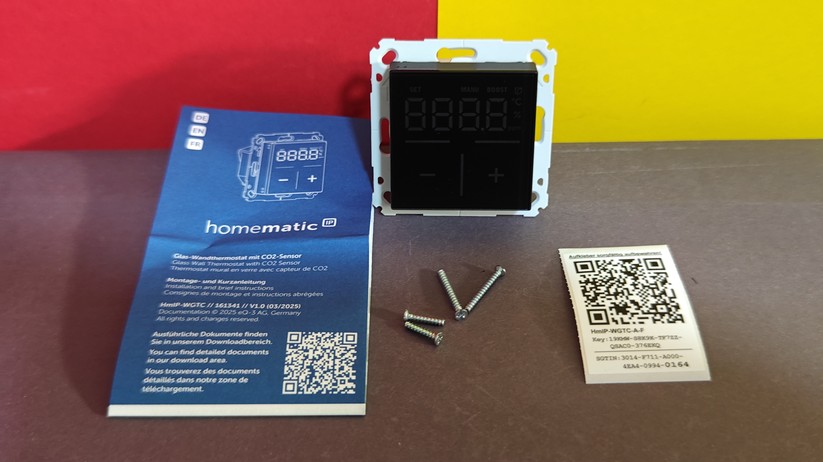 Das Homematic IP Glas-Wandthermostat mit CO₂-Sensor gibt es in Schwarz oder Weiß. Auf seinem Glas-Display kann es Temperatur, Luftfeuchte und CO₂-Konzentration abwechselnd anzeigen.