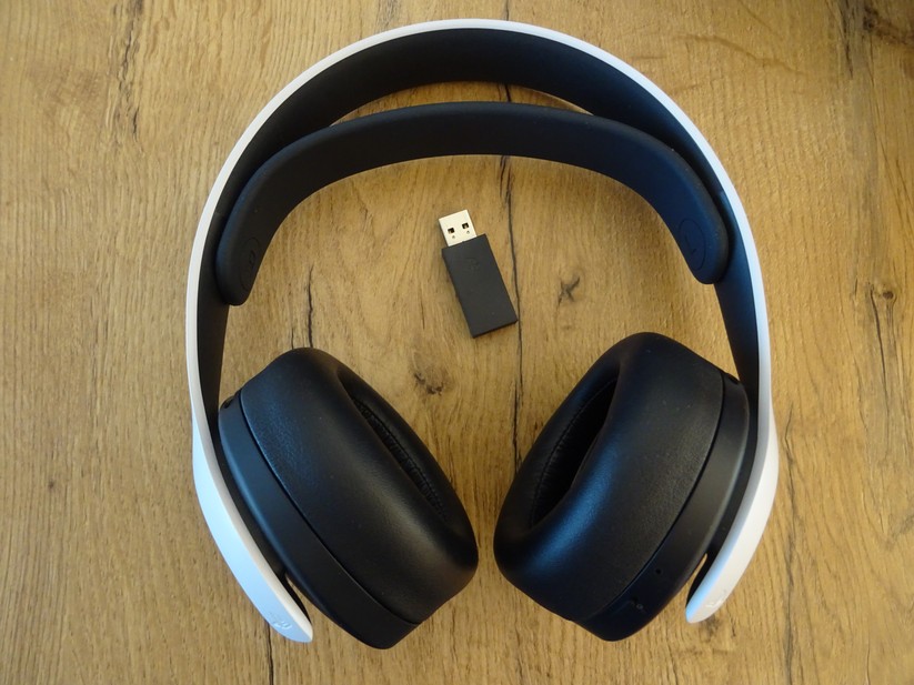 Das Pulse 3D Wireless Headset samt mitgeliefertem USB-Dongle.