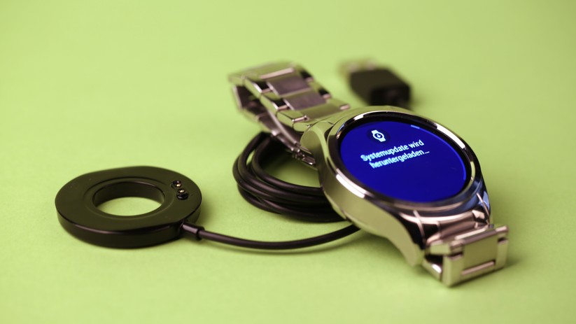 Das magnetische Ladekabel wird auf der Rückseite der Uhr aufgesetzt.