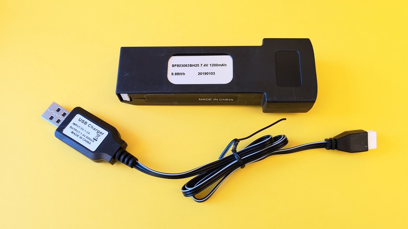Der Akku samt Ladegerät. Ein USB-Netzteil gehört nicht zum Lieferumfang.