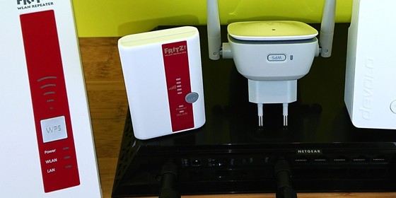 Die drei weißen WLAN-Repeater (2x AVM, 1x Devolo) haben ihren WPS-Taster direkt an der Front. Der weiß-graue Belkin N300 hat ihn unten. Der große, schwarze Netgear EX7000 hat den WPS-Knopf an seiner Hinterseite.