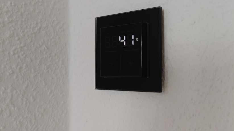 Das Homematic IP Glas-Wandthermostat mit CO₂-Sensor gibt es in Schwarz oder Weiß. Auf seinem Glas-Display kann es Temperatur, Luftfeuchte und CO₂-Konzentration abwechselnd anzeigen.